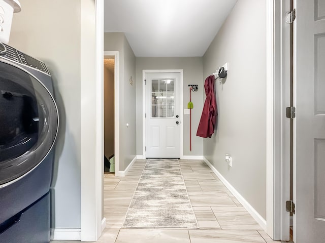 laundry area featuring laundry area, baseboards, and washer / clothes dryer