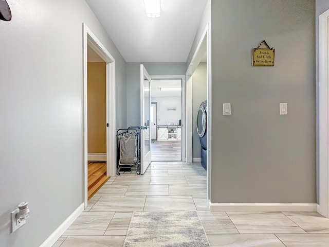 hall featuring washer / dryer and baseboards