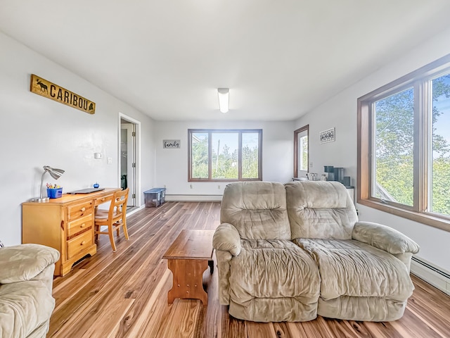 living room with a healthy amount of sunlight, a baseboard radiator, a baseboard heating unit, and wood finished floors