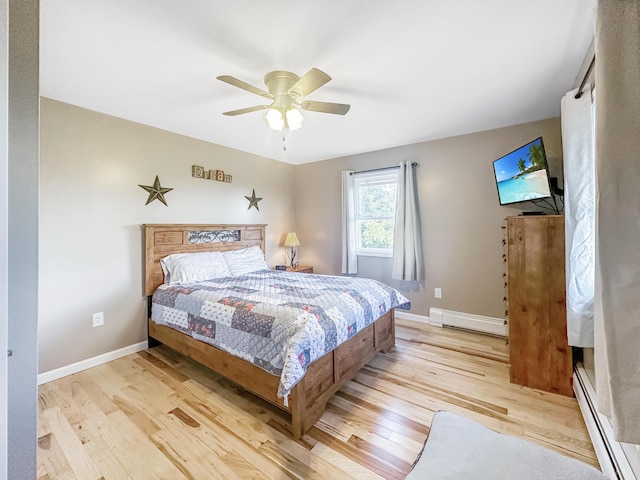 bedroom featuring a baseboard radiator, light wood-style flooring, and baseboards