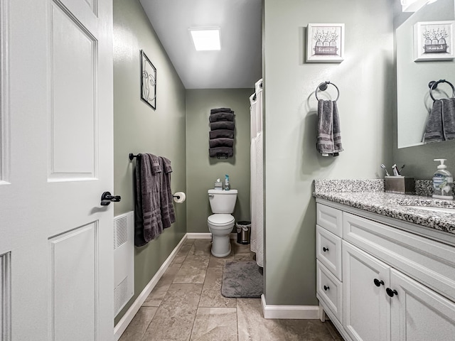 full bath featuring toilet, vanity, and baseboards