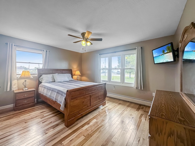 bedroom featuring light wood-style floors, baseboards, ceiling fan, and baseboard heating