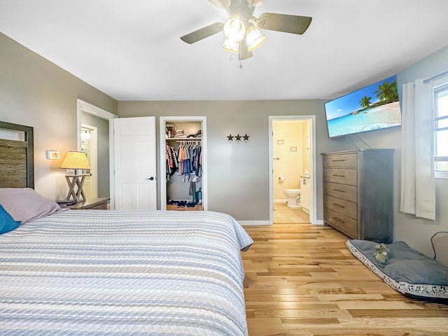 bedroom with a walk in closet, a closet, light wood-style flooring, connected bathroom, and ceiling fan