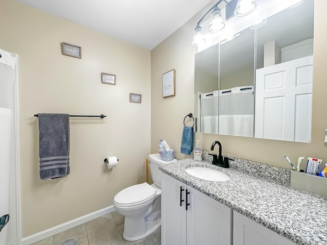 bathroom featuring baseboards, vanity, toilet, and tile patterned floors