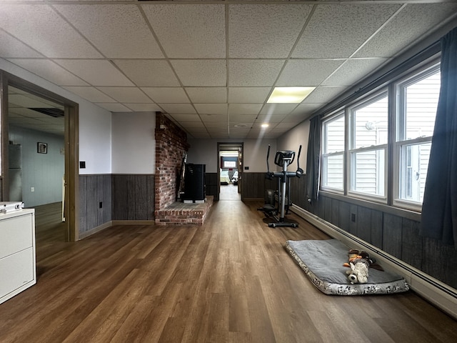 workout room featuring a drop ceiling, wood finished floors, and wainscoting