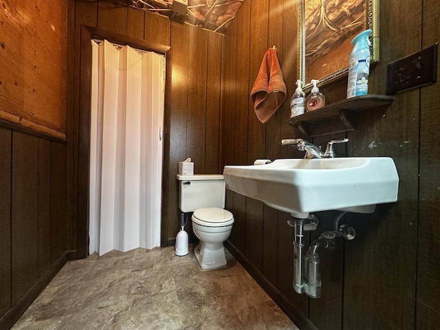 half bathroom featuring toilet and wooden walls