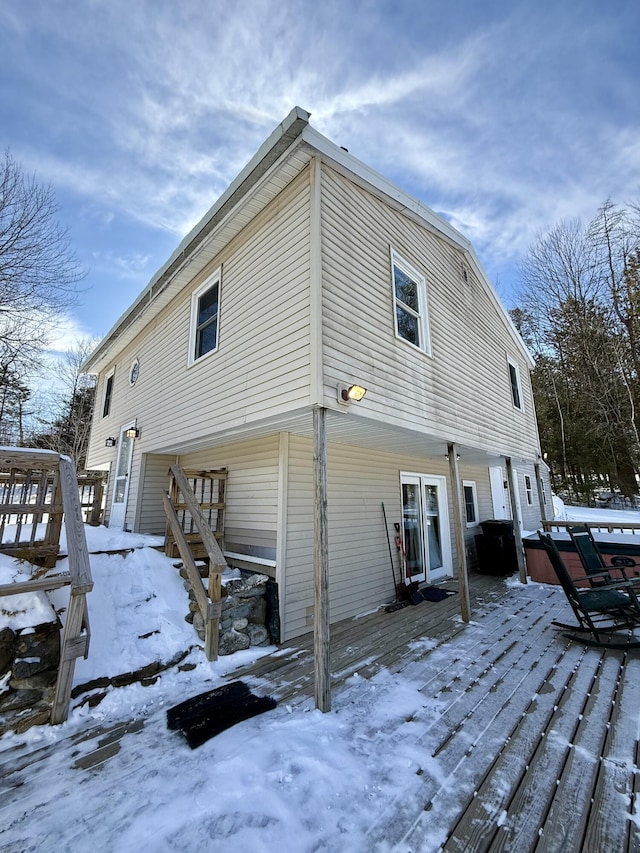 snow covered rear of property with a wooden deck