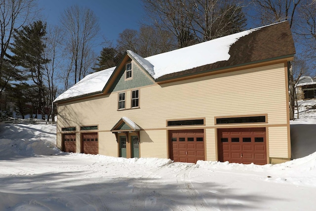 view of snow covered exterior featuring a garage