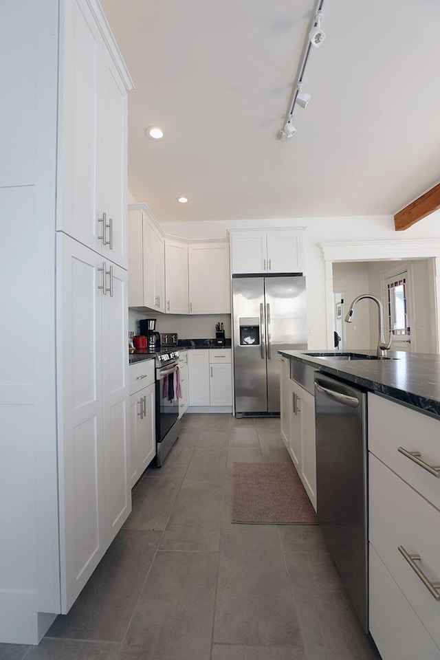 kitchen with stainless steel appliances, dark countertops, recessed lighting, white cabinets, and a sink