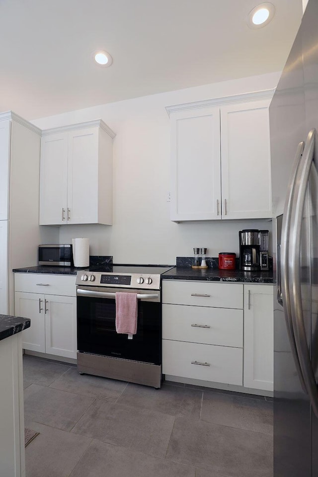 kitchen featuring dark countertops, white cabinetry, and stainless steel appliances