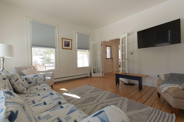 living area featuring light wood-style flooring and a baseboard heating unit