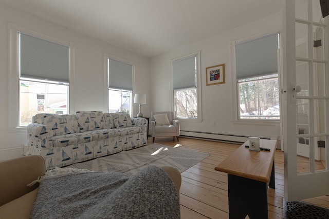 living room with light wood-style floors and a baseboard heating unit