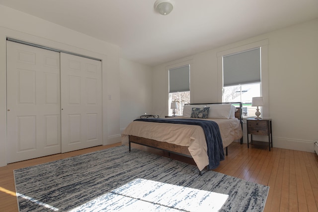 bedroom featuring a closet, wood finished floors, and baseboards