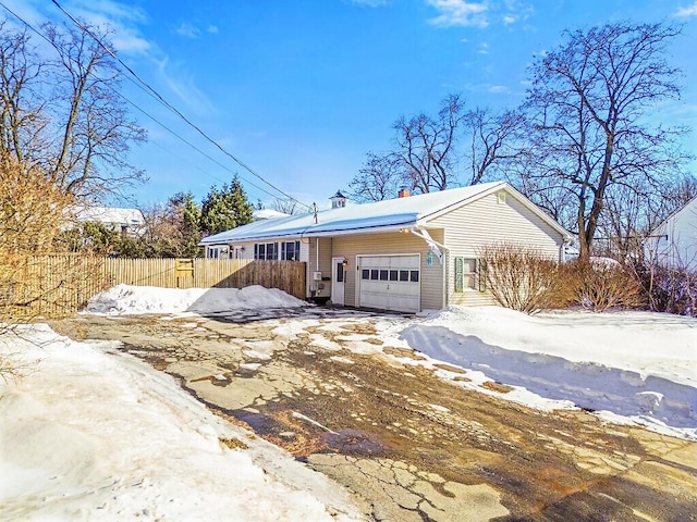 view of front of house with fence, a chimney, and an attached garage