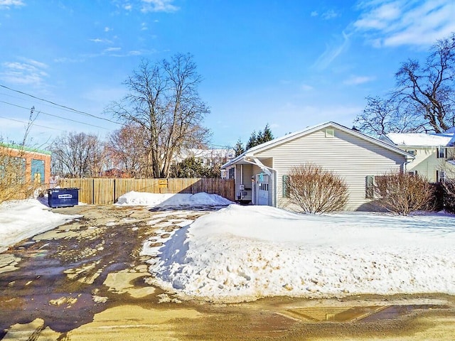 view of snow covered exterior featuring fence