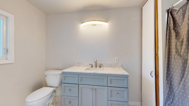 full bath featuring toilet, vanity, and a shower with curtain