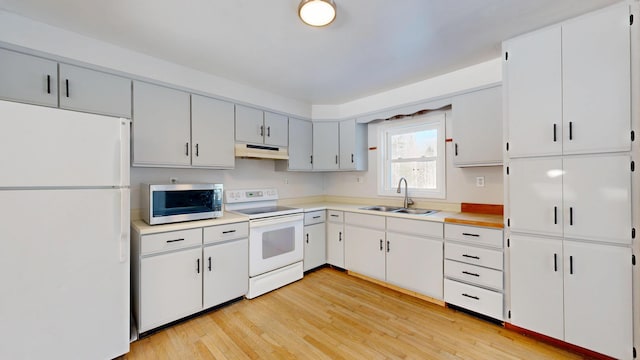 kitchen with light countertops, white cabinetry, a sink, white appliances, and under cabinet range hood