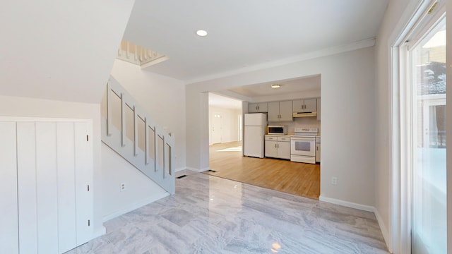 unfurnished living room with marble finish floor, stairway, and baseboards