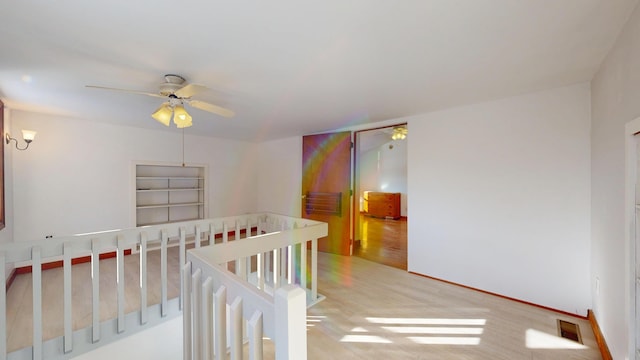 bedroom featuring light wood-style floors, ceiling fan, visible vents, and baseboards