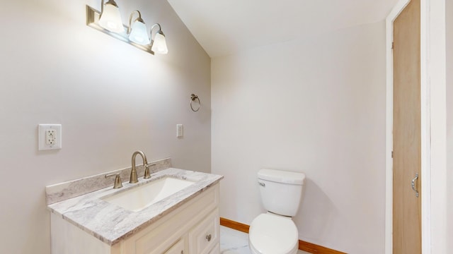 half bath featuring toilet, vanity, and baseboards