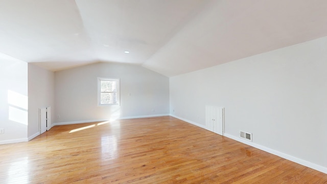 bonus room with lofted ceiling, visible vents, light wood-style flooring, and baseboards