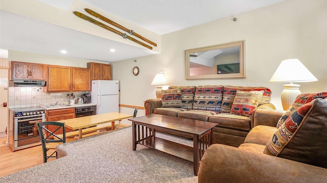 living area with a textured ceiling, recessed lighting, and light wood-style floors