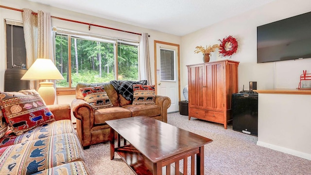 living area featuring light colored carpet and baseboards