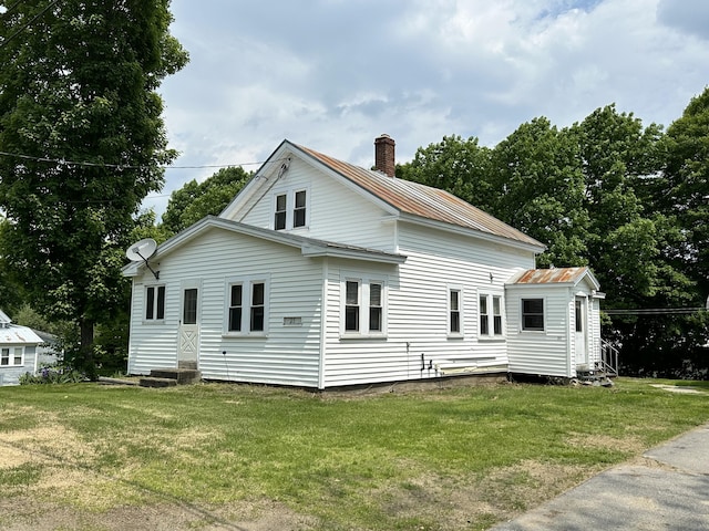 25 School St, Kingfield, ME 04947 - view of side of home featuring entry steps, a chimney, a metal roof, and a yard
