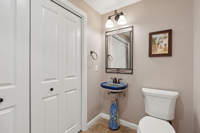 bathroom featuring baseboards and toilet