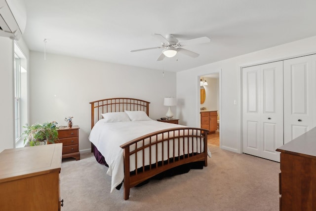 bedroom featuring ceiling fan, ensuite bathroom, light carpet, baseboards, and a closet