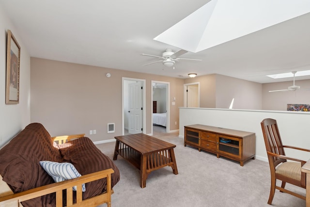 living room featuring a ceiling fan, a skylight, light colored carpet, and visible vents