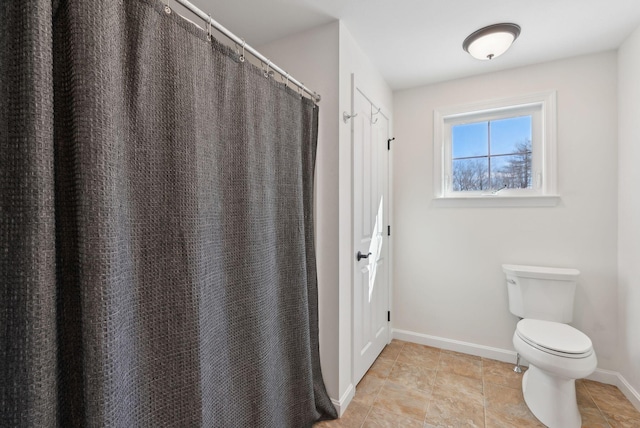 bathroom with toilet and baseboards