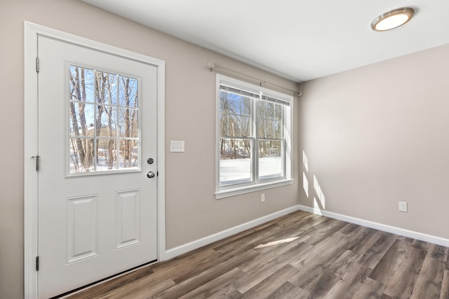 doorway with baseboards and wood finished floors