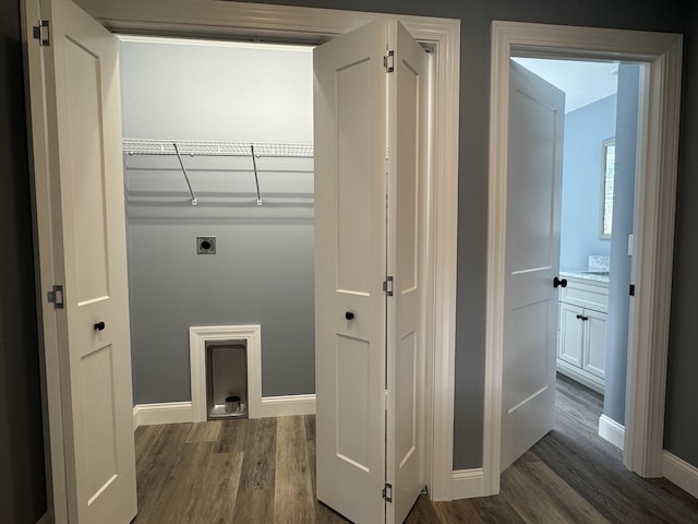 laundry area featuring laundry area, dark wood-style flooring, electric dryer hookup, and baseboards