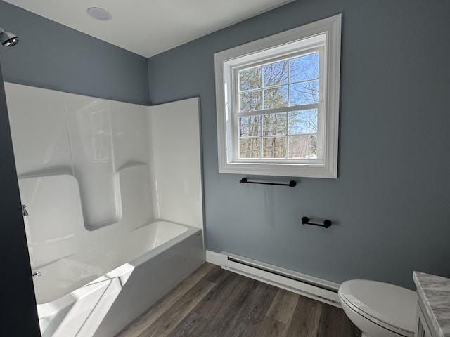 bathroom featuring toilet, a baseboard heating unit, vanity, wood finished floors, and baseboards