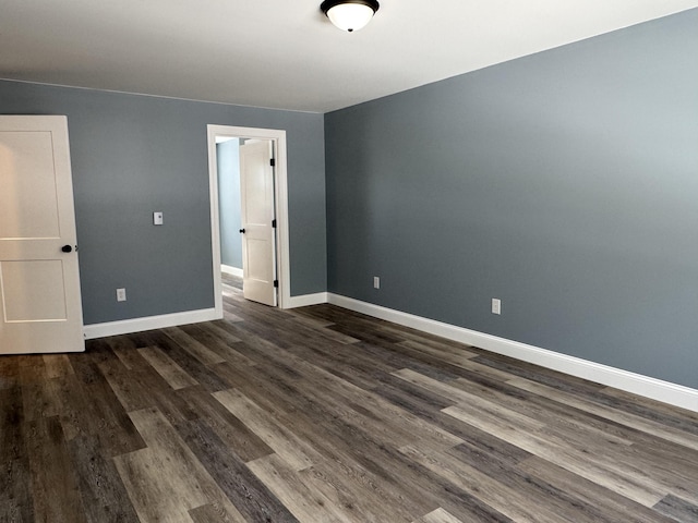 unfurnished bedroom with baseboards and dark wood-type flooring