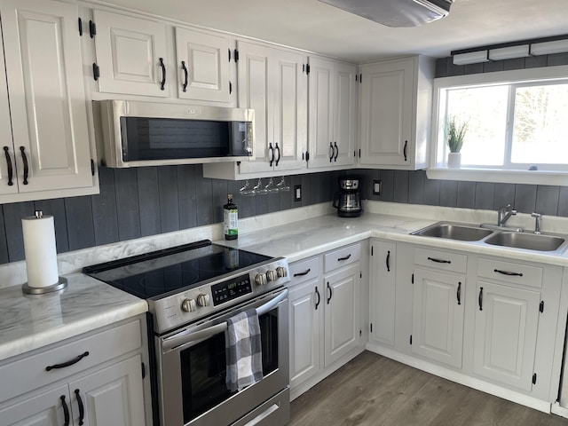 kitchen featuring dark wood-style floors, white cabinetry, appliances with stainless steel finishes, and a sink