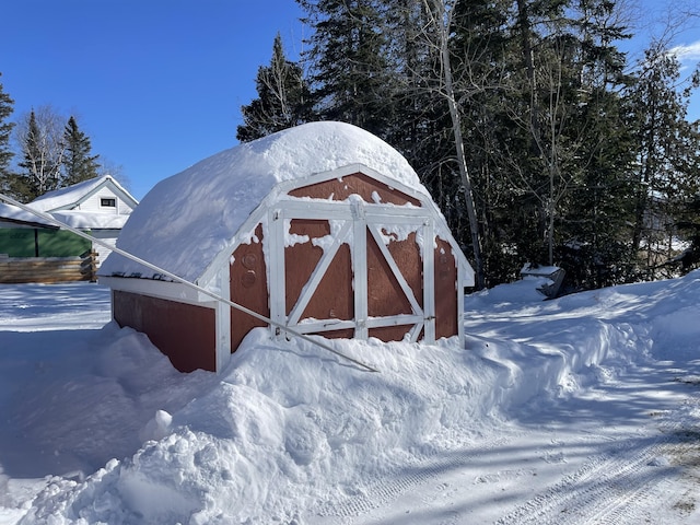 snow covered structure with an outbuilding