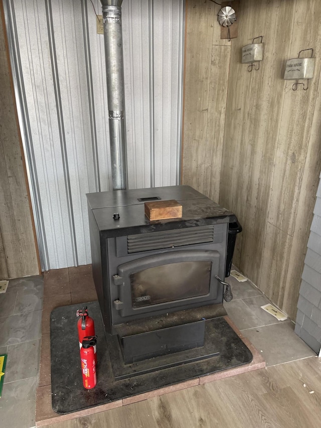 interior details featuring a wood stove, wooden walls, and a fire extinguisher