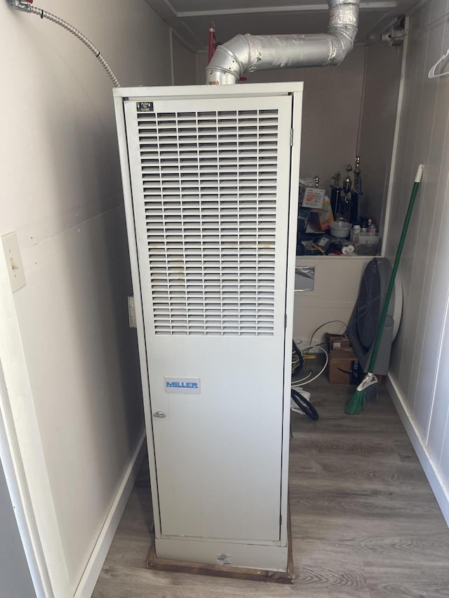 details featuring a heating unit, baseboards, and wood finished floors