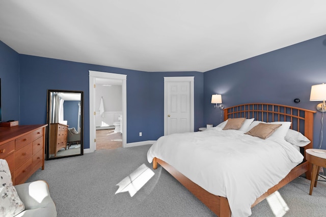 bedroom with ensuite bathroom, carpet floors, baseboard heating, and baseboards