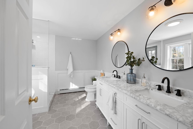 full bath featuring a walk in shower, toilet, a baseboard heating unit, a sink, and wainscoting