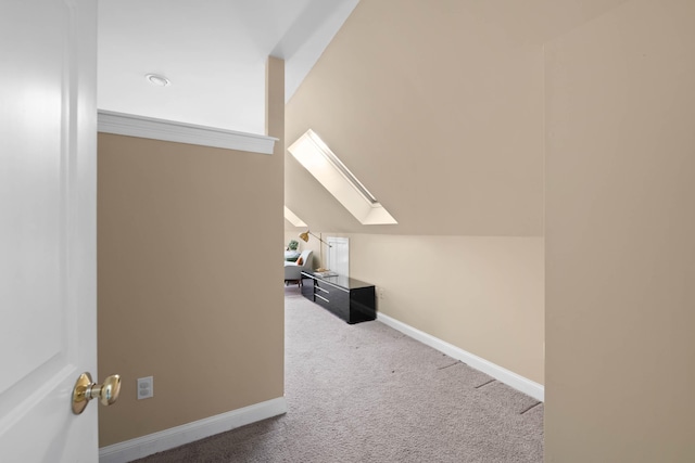 additional living space with vaulted ceiling with skylight, carpet flooring, and baseboards