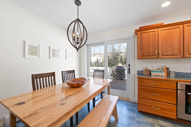 dining space featuring recessed lighting, a notable chandelier, dark tile patterned floors, and a baseboard radiator