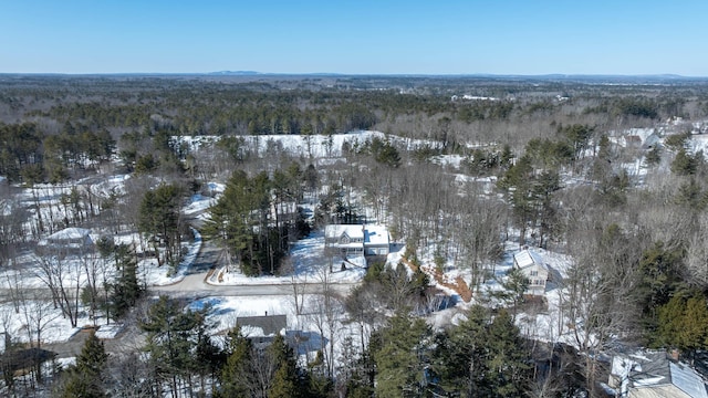 snowy aerial view featuring a forest view