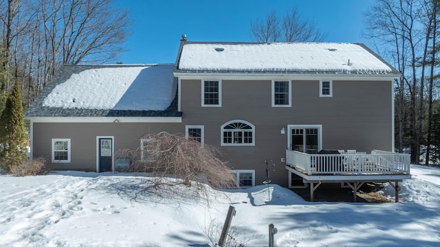 snow covered house with a wooden deck