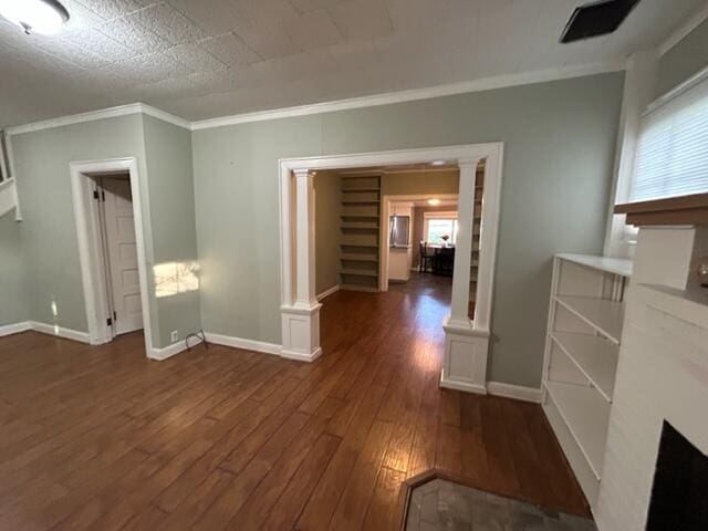 interior space featuring crown molding, dark wood finished floors, decorative columns, a healthy amount of sunlight, and baseboards