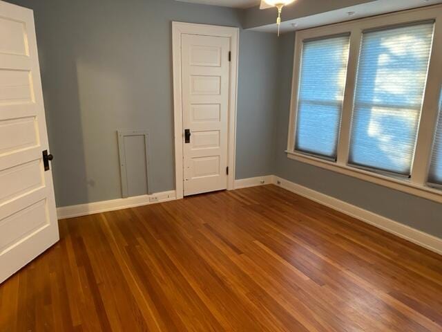 empty room featuring dark wood finished floors and baseboards