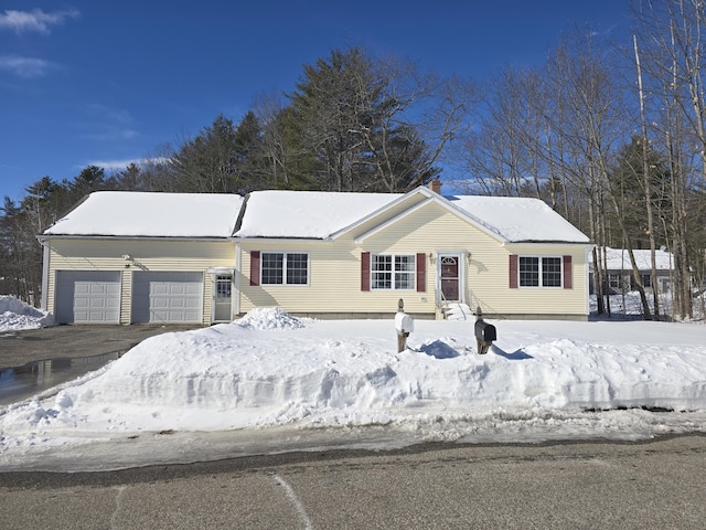 single story home featuring entry steps, driveway, and an attached garage