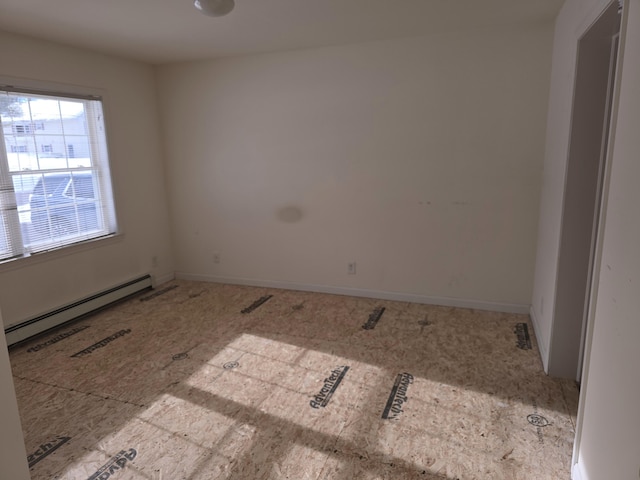 unfurnished room with baseboard heating and baseboards